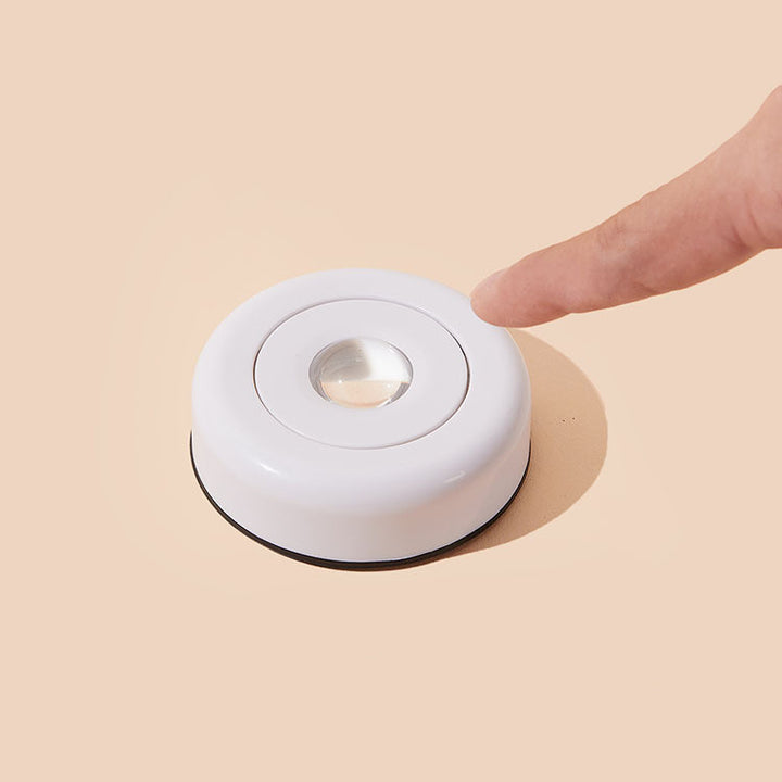 Trykklampe som lyser oransje på vegg