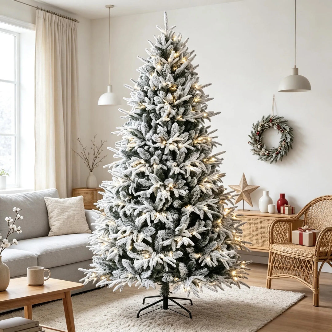 Fyldig snødekt juletre med varmhvite lys