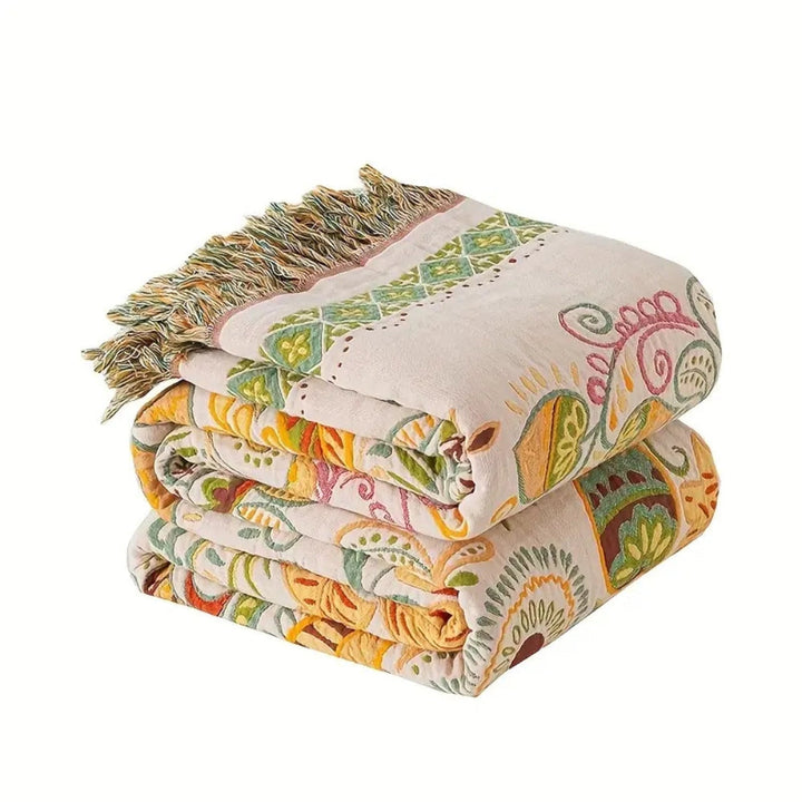 Vendbar boho-pledd med dusker og løvmønster