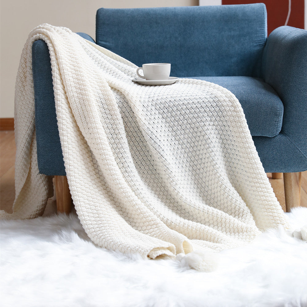 Vevd pledd i plysj med elegant mønster til sofaen
