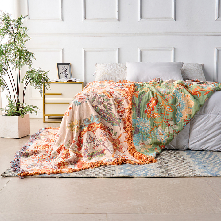 Blomstret boho-pledd i bomull med frynser i oransje og blått