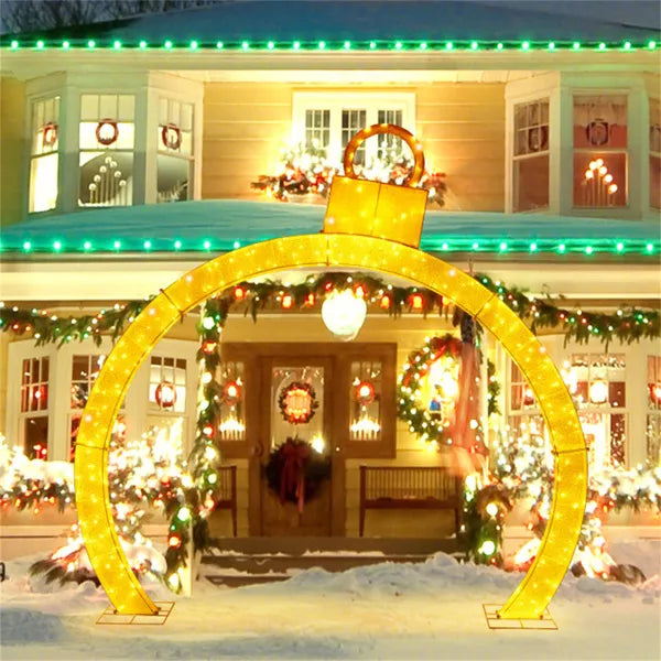 Lysende juleport med julekuler i hagen