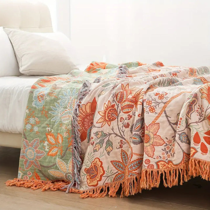 Blomstret boho-pledd i bomull med frynser i oransje og blått