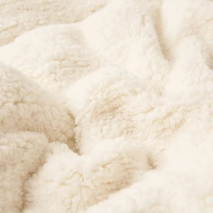 Vendbart sherpateppe i fleece til seng og sofa