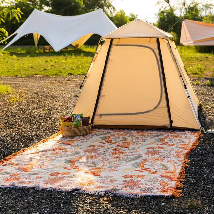 Blomstret boho-pledd i bomull med frynser i oransje og blått